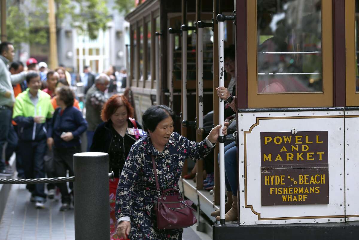 Passengers climb aboard a cable car at Powell and Market streets in San Francisco, Calif. on Saturday, April 22, 2017. Muni may eliminate cash fares on board the world famous cable cars after a brakeman was accused of stealing the fares.