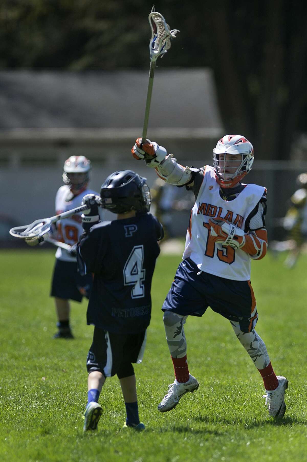 BRITTNEY LOHMILLER | blohmiller@mdn.net Midland Orange 14UA's Ryan Pomranky jumps to block Petoskey's Tate Wilder's pass during the Midland Lacrosse Club's Honor the Game tournament Saturday at Jefferson Middle School. Midland defeated Petoskey 11-3.