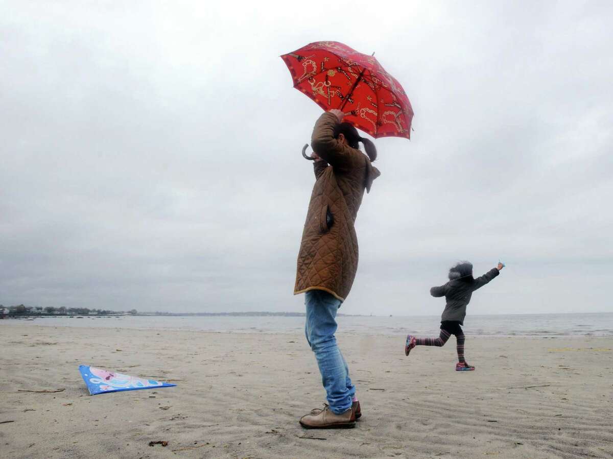 As a woman holding an umbrella watches, a young girl attempts to launch her kite during the Greenwich Kite Flying Festival that was held at Greenwich Point, Conn., Saturday afternoon, April 22, 2017. Roughly 30 devoted participants launched or attempted to launch their kites in the rain and low wind during low-tide on the beach. Patricia Toriano of the Greenwich Parks Department said the India Cultural Center of Greenwich, a co-sponsor of the event, could not fly their Patang kites, also known as Indian fighter kites, in the rain because they are made of paper. Troiano said the Indian Cultural Center kite flyers will be at the point on Sunday at 2 p.m. and if the weather is permitting, will give a Patang flying demonstration as well as show how their kites are constructed.