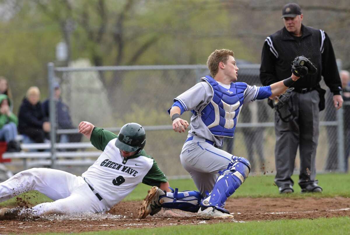 New Milford’s Derek Johnson (9) slides safely into home as Newtown catcher Ben Harrison catches the throw during their game Saturday at New Milford High School. New Milford rallied to earn an 8-7 win in 10 innings.