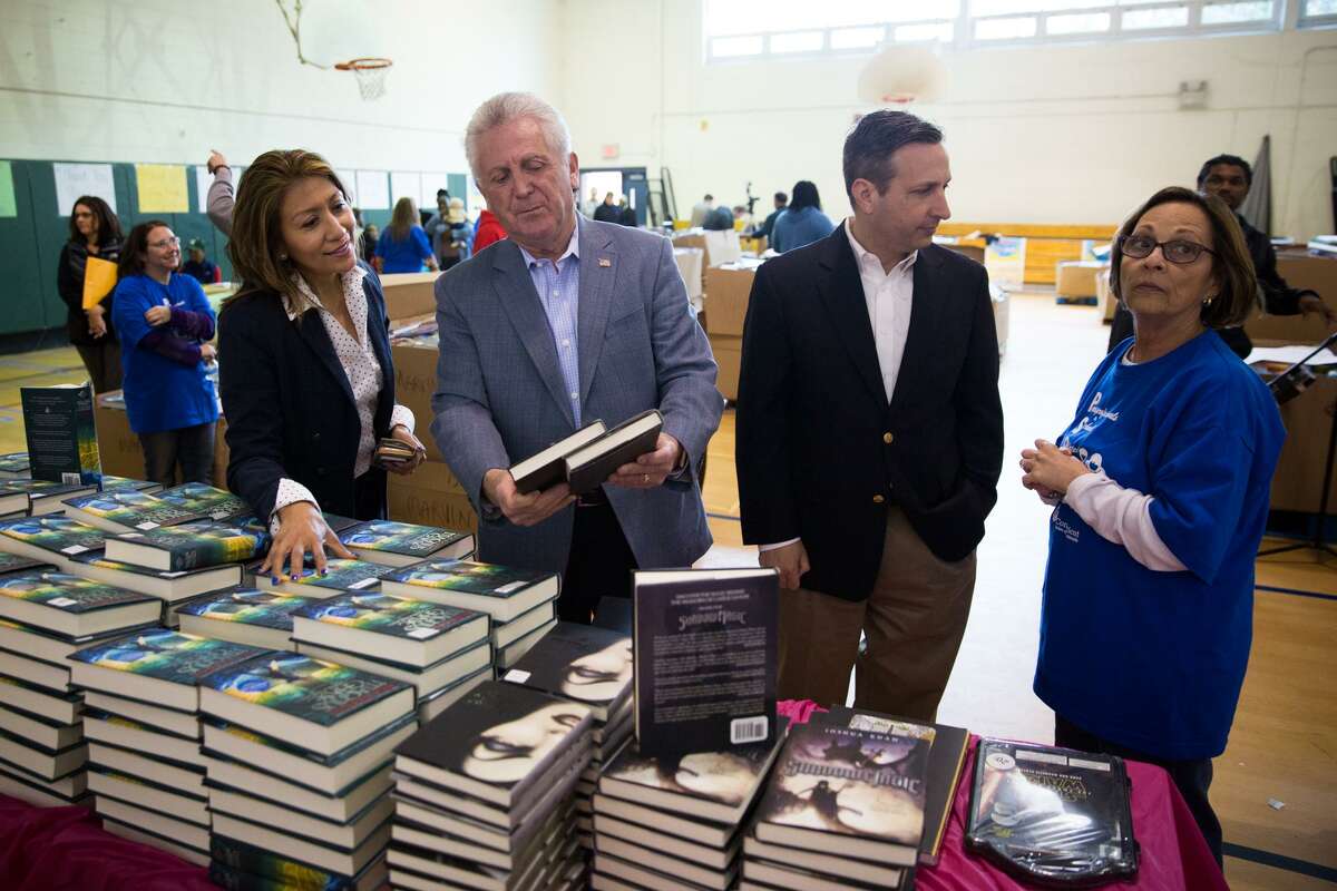 El alcalde de Norwalk, Harry Rilling, y el senador estatal.  Bob Duff mira algunos de los libros entregados el sábado 22 de abril de 2016 en la escuela secundaria Bonus Ridge en Norwalk.  Bonus Ridge ofreció libros gratis a sus estudiantes como parte del primer libro.  Intentar.  El Distrito Escolar de Norwalk recibió 40,000 libros del primer libro.