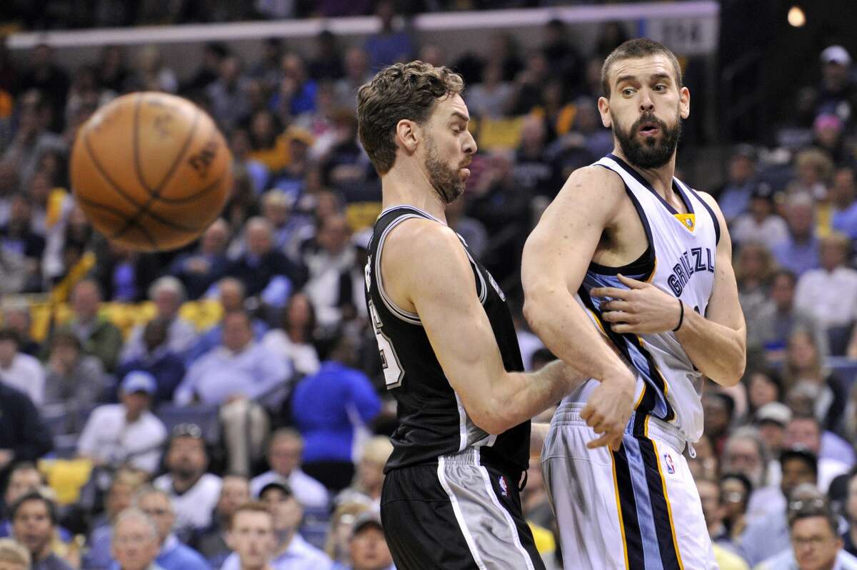 Memphis Grizzlies center Marc Gasol, right, passes the ball around his brother San Antonio Spurs center Pau Gasol during the first half of Game 4 in an NBA basketball first-round playoff series Saturday, April 22, 2017, in Memphis, Tenn. (AP Photo/Brandon Dill)