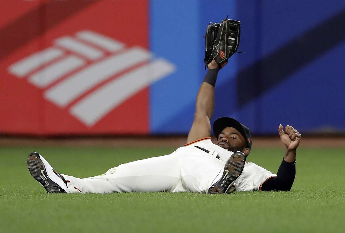 San Francisco Giants center fielder Denard Span holds his glove up after making a sliding catch on a pop fly from Colorado Rockies' Trevor Story during the eighth inning of a baseball game, Thursday, April 13, 2017, in San Francisco. (AP Photo/Marcio Jose Sanchez)