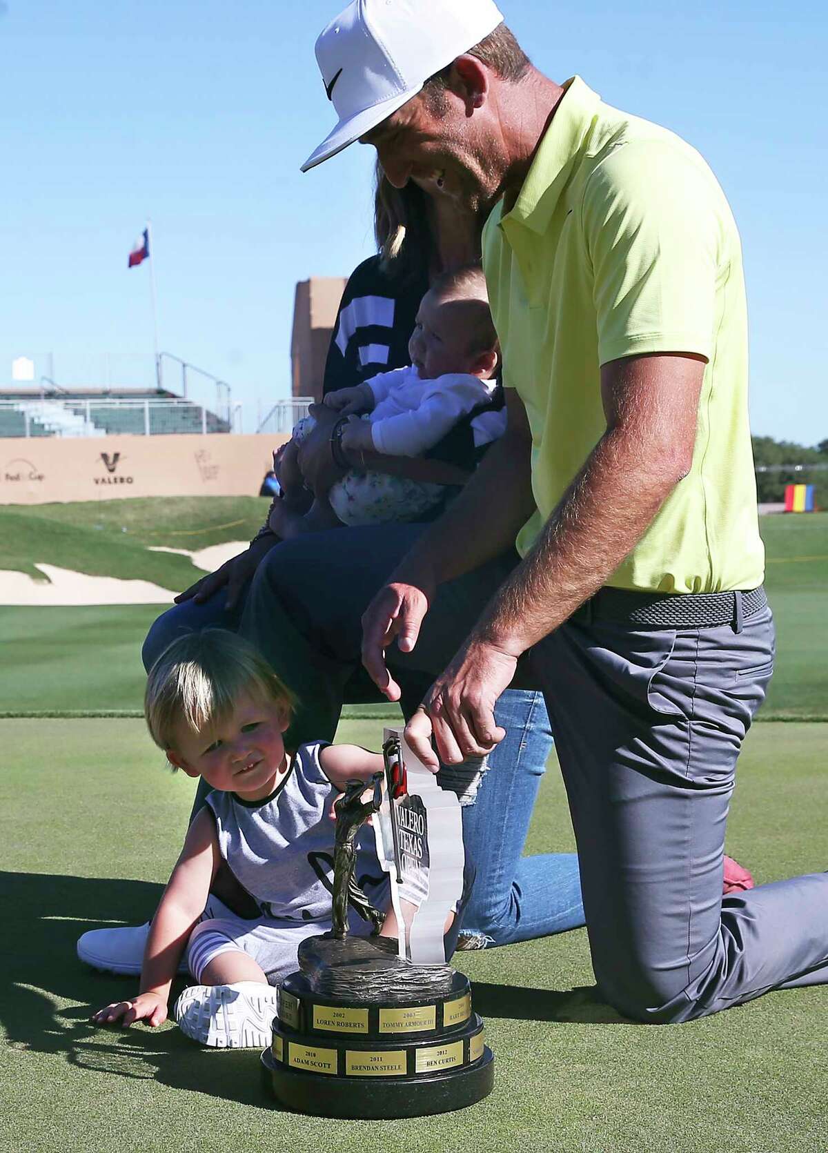Two year old Wyatt Chappell shows immediate interest in the trophy as he gets in a family photo with the champion Kevin Chappell after the final round of the Valero Texas Open at TPC San Antonio Oaks Course on April 23, 2017.