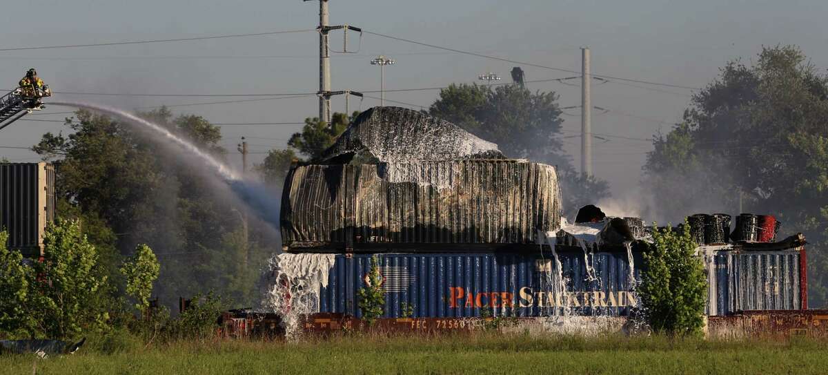 HFD firefighters working on to put off fire from a shipping container on the railroad near Conti and Chapman Streets Sunday, April 23, in Houston. The items inside the shopping container are visible after the metal walls fell apart.