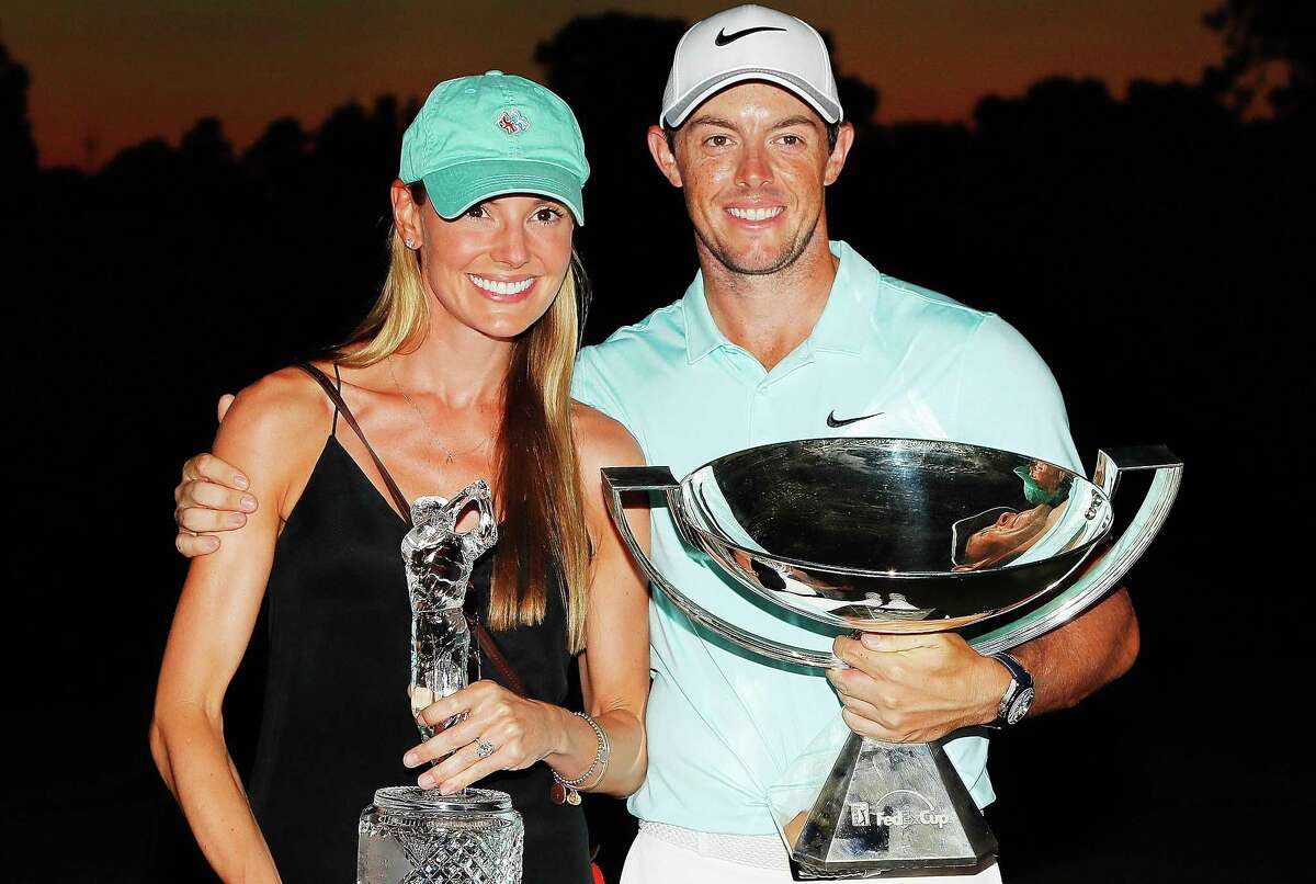 Rory McIlroy of Northern Ireland poses alongside Erica Stoll as they hold the FedExCup and Tour Championship trophies at East Lake Golf Club on Sept. 25, 2016 in Atlanta.