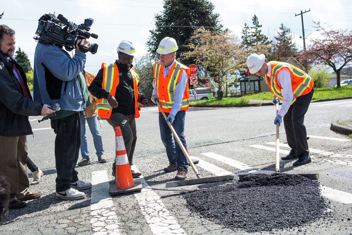 Seattle Mayor Ed Murray and SDOT director Scott Kubly try their hand at filling in potholes at Beacon Avenue South and South Orcas Street on Wednesday, April 19, 2017.