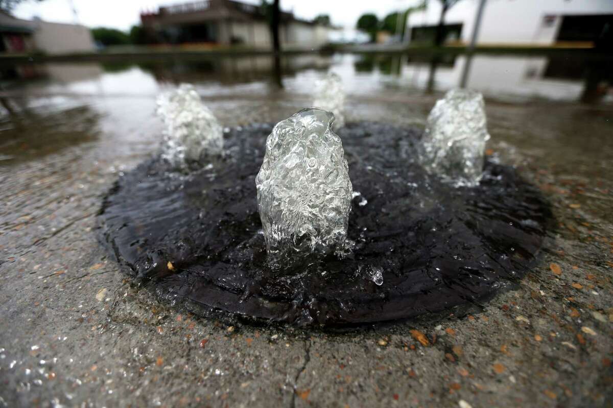 Water bubbles up from a storm drain on South Braeswood last April. County officials are thinking about ways to use excessive rainwater as a resource.