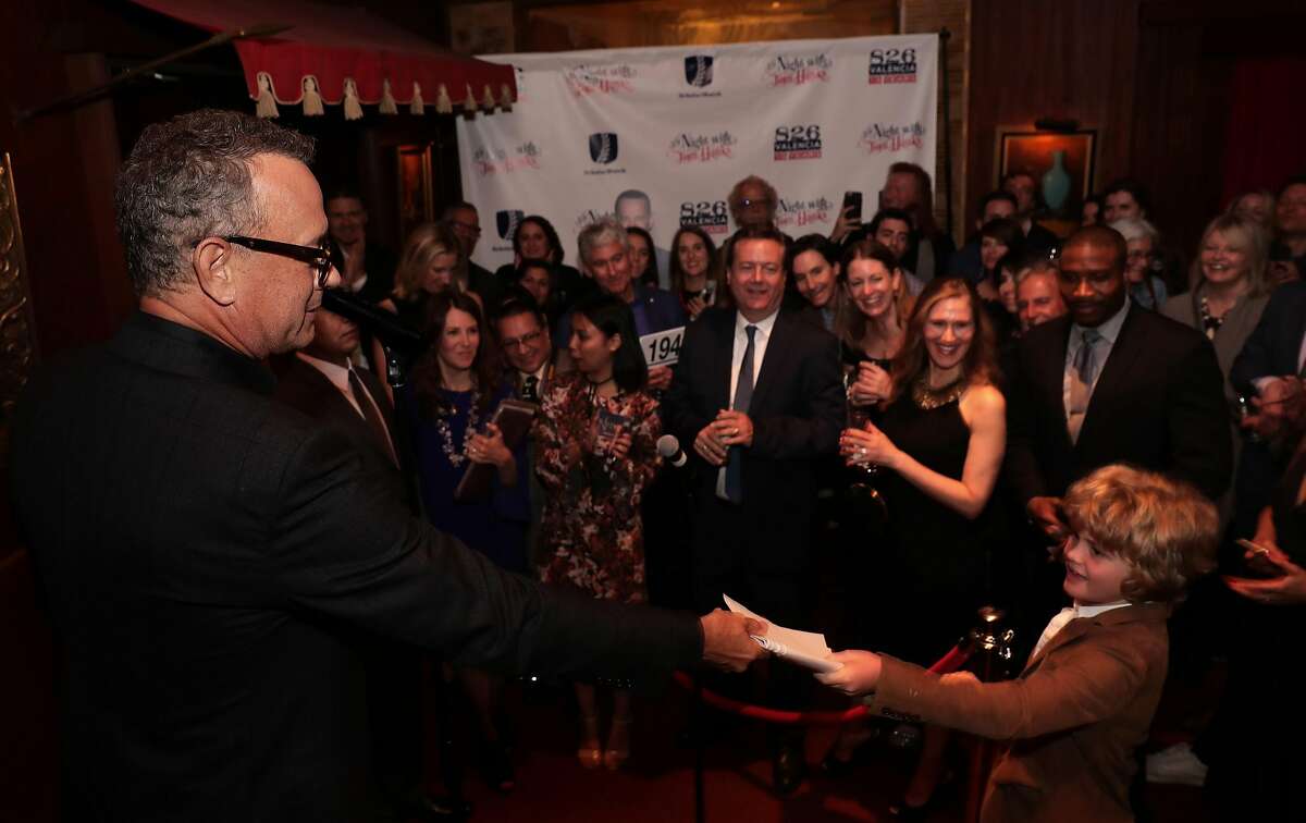 Special guest Tom Hanks gives his copy to 11-year-old Oliver Yeaman, of San Francisco after reading from his new book Uncommon Type: Some Stories, during a fundraiser to benefit 826 Valencia and ScholarMatch, at Bimbo's 365 Club in San Francisco, Calif., on Monday April 24, 2017.