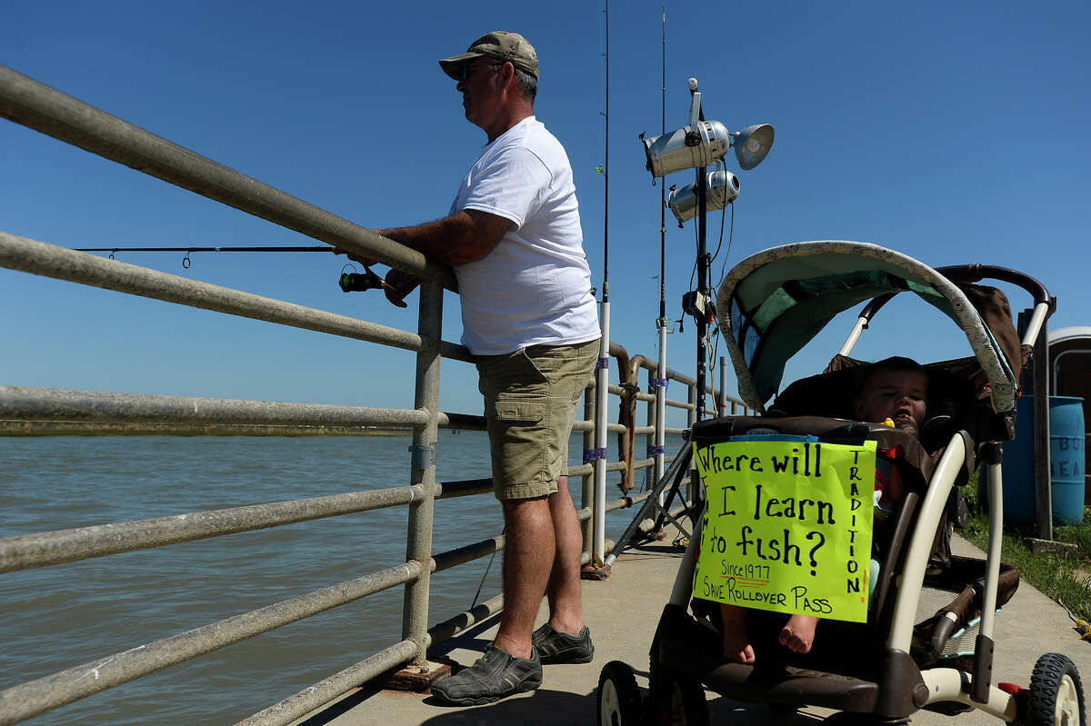 James Simon, of Huntsville, fishes with his 1-year-old daughter, Aunika, at Rollover Pass on the Bolivar Peninsula on Monday afternoon. Simon has been coming to the popular fishing spot since 1977 and often brings his camper down to camp on the pass. Photo taken Monday 4/24/17 Ryan Pelham/The Enterprise