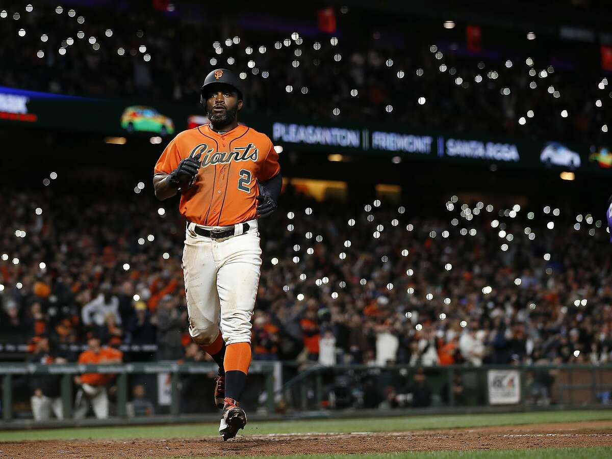 San Francisco Giants' Denard Span (2) scores a run on a single by Brandon Belt against the Colorado Rockies during the seventh inning of a baseball game, Friday, April 14, 2017, in San Francisco. Fans light up the stands with their phones. TheGiants won 8-2. (AP Photo/Tony Avelar)