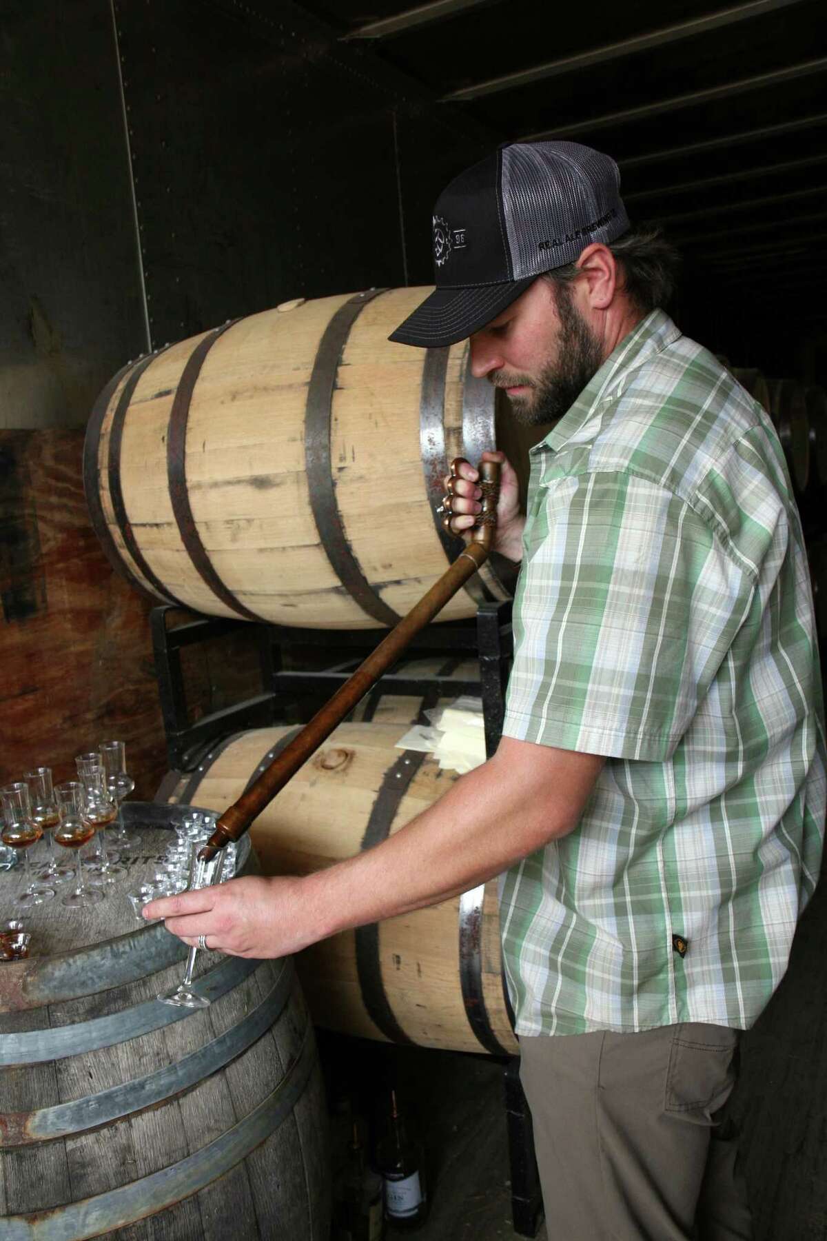 Real Spirits distiller Davin Topel prepares sample glasses for a tour in one of their barrel storage facilities, or rickhouses.