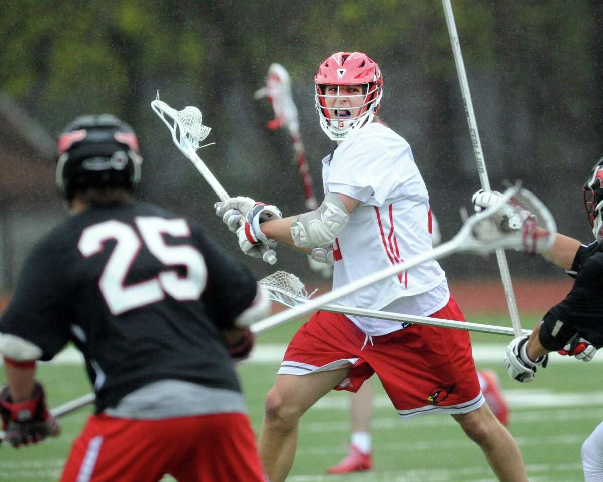 At center, Zach Tucker of Greenwich prepares to unlease a shot on goal as Jack Curtis (25) of Fairfield Warde, left, defends during the boys high school lacrosse match between Greenwich High School and Fairfield Warde High School at Greenwich, Conn., Tuesday, April 25, 2017.