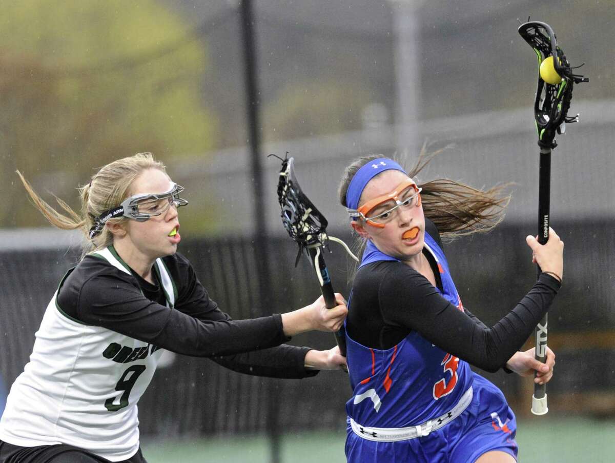 Danbury's Marissa Volpe (3) brings the ball out from behind the Danbury goal while being defended by New Milford's Kelsie Baxter (9) in the girls lacrosse game between Danbury and New Milford high schools, on Tuesday afternoon, April 25, 2017, at New Milford High School, in New Milford, Conn.