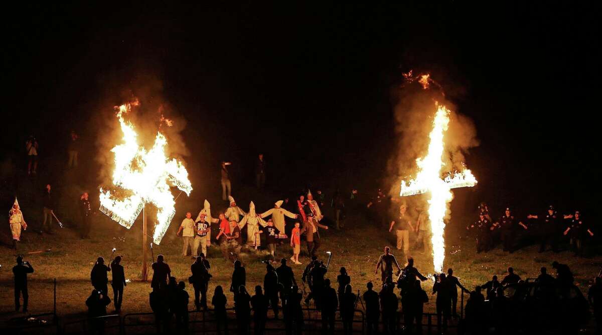 ﻿In 2016, members of the Ku Klux Klan ﻿burn a cross and swastika after a "white pride" rally ﻿in Georgia. ﻿The Klan is among groups that have consolidated into the Nationalist Front.