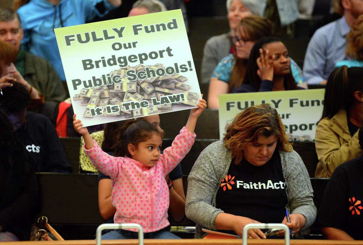 Yarieliz Pagan, 4, holds up a sign demading the city fund the public schools as she and hundreds of parents came out to give the City Council their views Tuesday night.