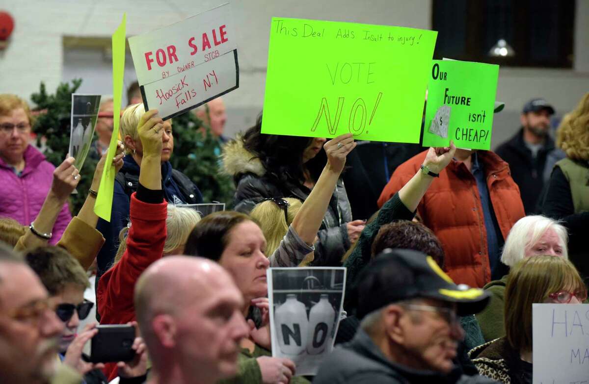 Residents opposed to a revised proposed PFOA settlement hold signs as they try to urge board members to vote no on the proposal during a Village of Hoosick Falls board meeting on Monday, Feb. 27, 2017, in Hoosick Falls, N.Y. (Paul Buckowski / Times Union)