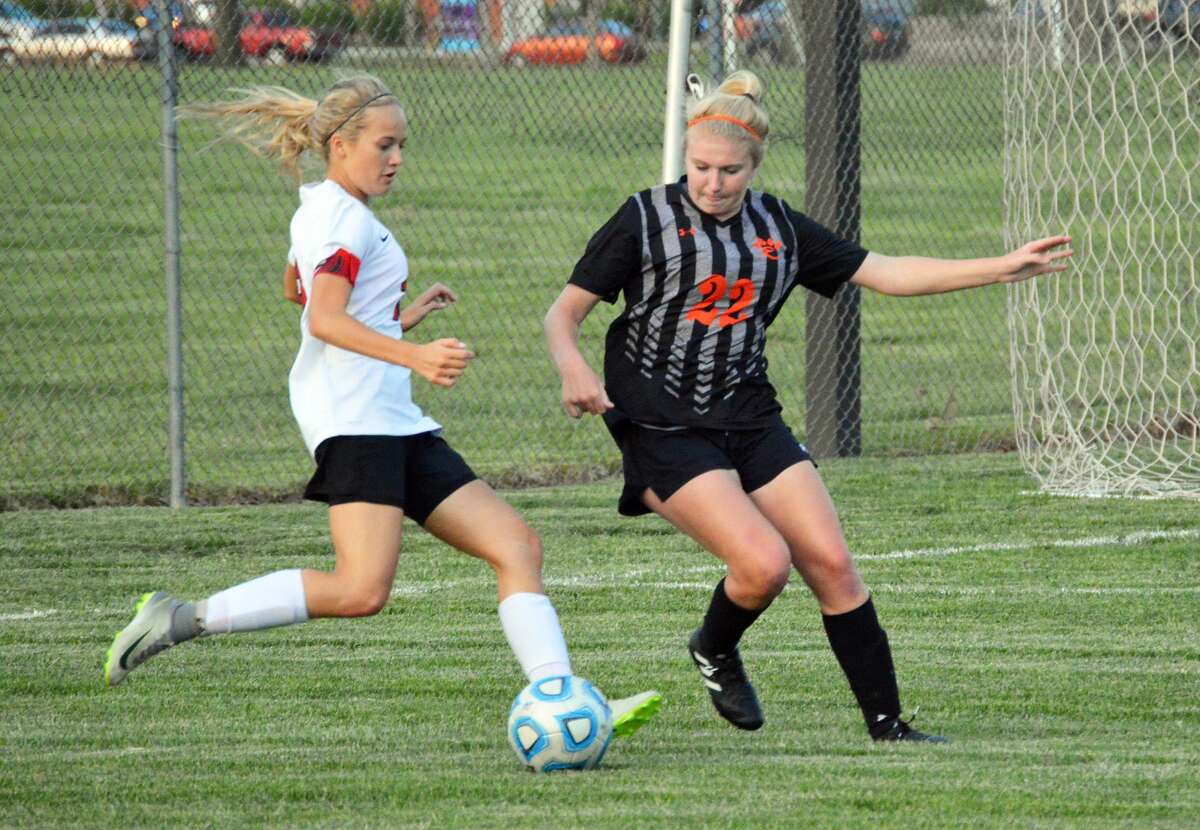 Edwardsville senior defender Taylor Hansen, right, tries to steal the ball late in the first half of Tuesday’s game in Granite City.