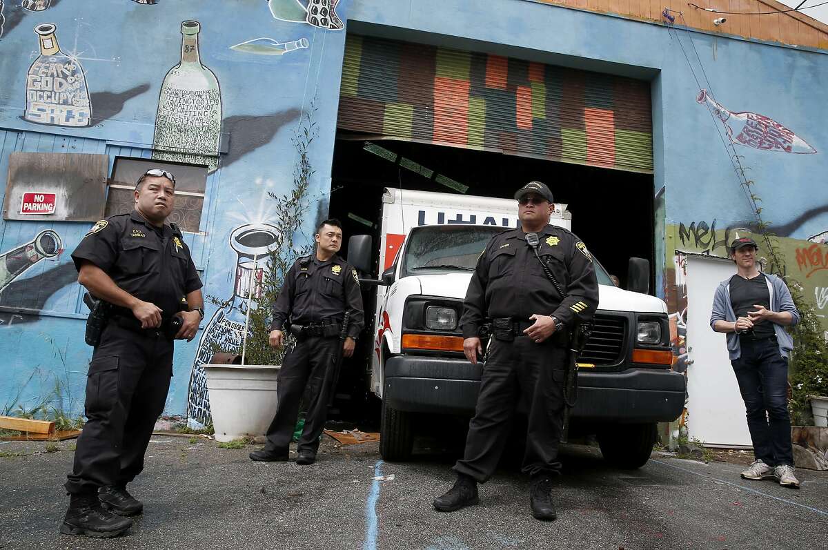 Nathan Cottam (right) stands outside of the Bernal Haus artist collective after sheriffs deputies evicted him and other residents living in a warehouse on Peralta Street in San Francisco, Calif. on Wednesday, April 26, 2017.
