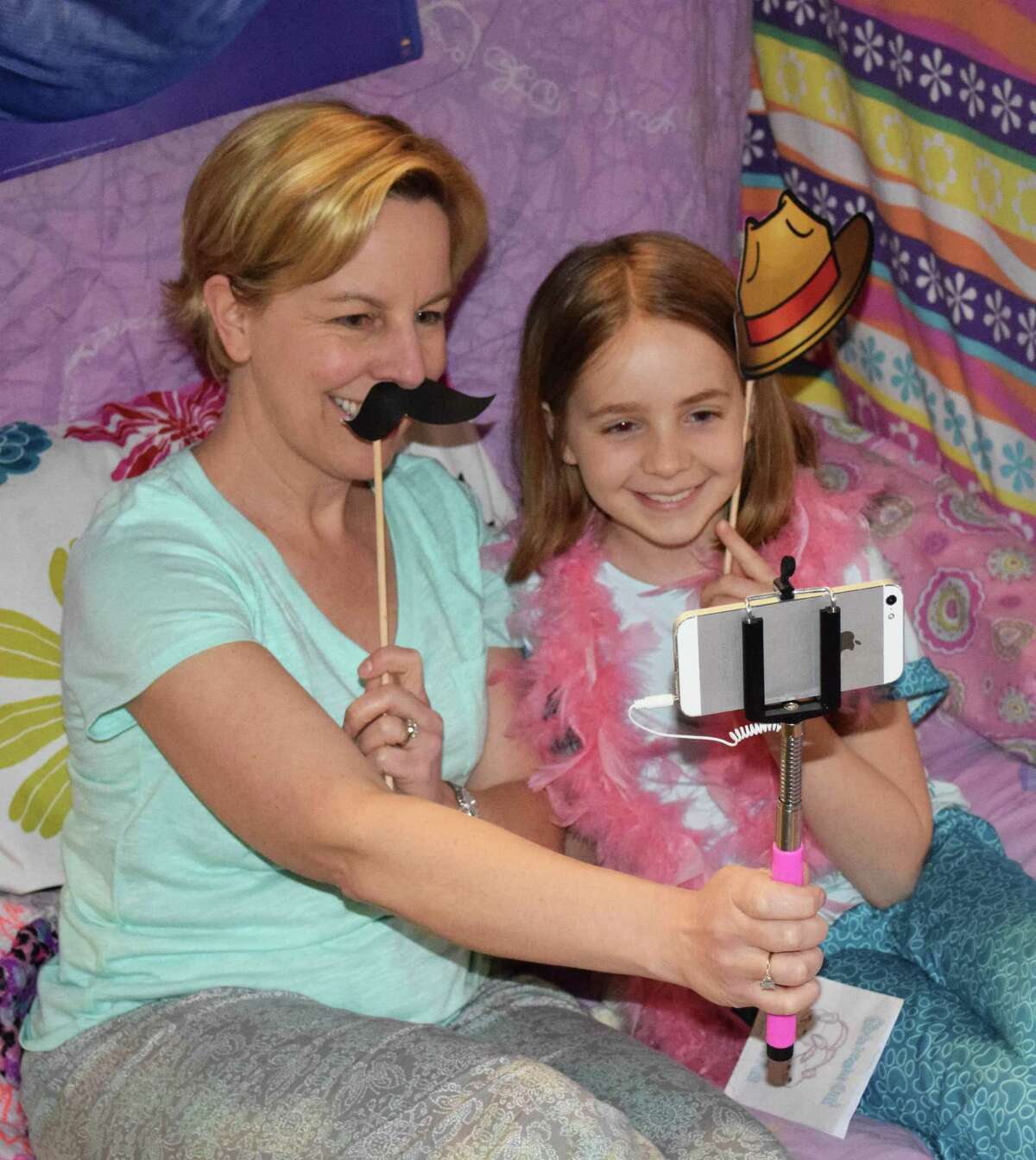 Michele MacDonnell and her daughter, Brynn, 8, capture a lighthearted moment together at the selfie station, one of several stations set up at the Girls' Night Out event, co-hosted by New Milford Girl Scout Troops 40326 and 40325 April 21, 2017, at New Milford High School. The mother-daughter event was based on a pajama party theme.