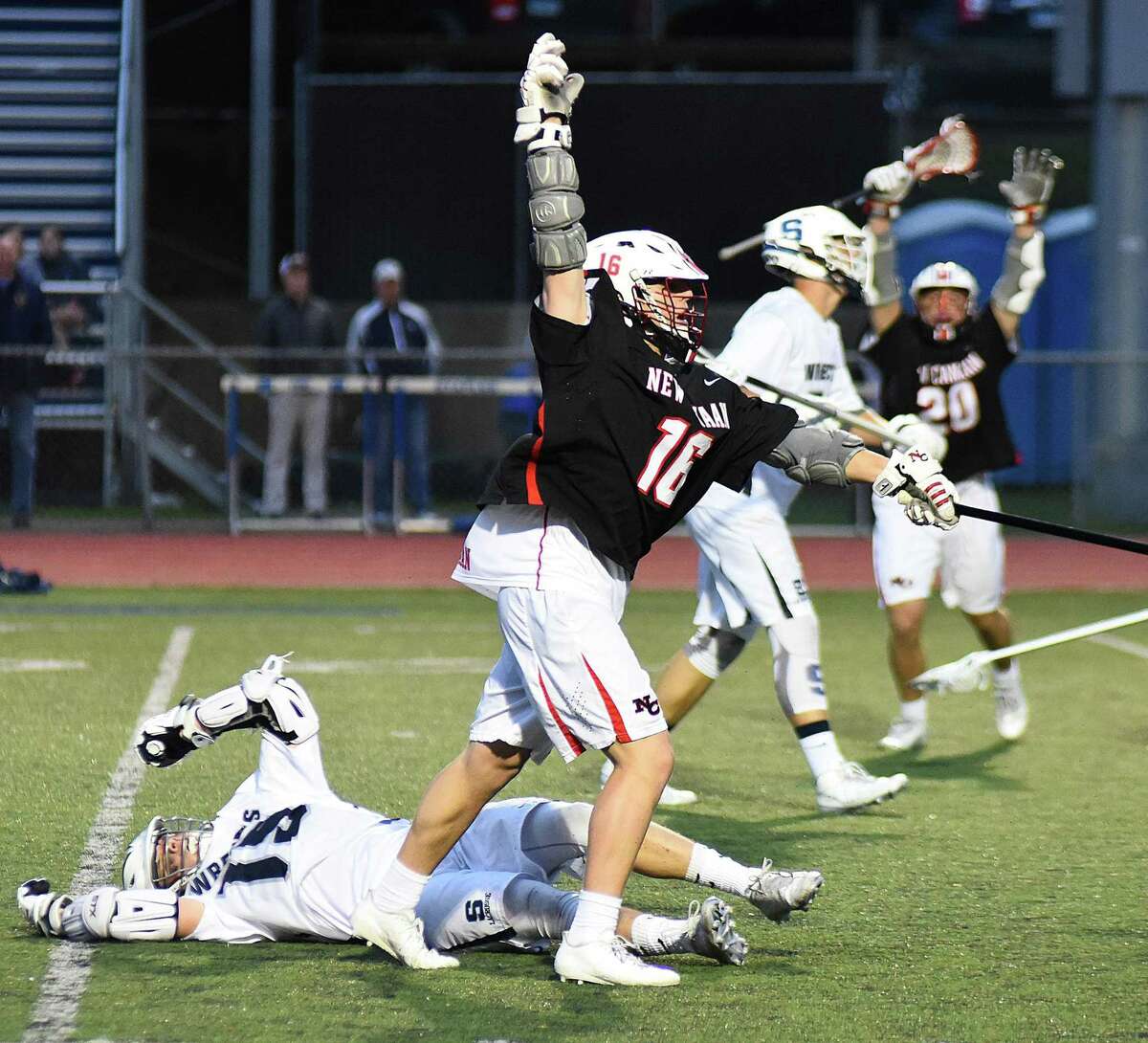 New Canaan's Graham Braden, center, reacts after scoring the game-winning goal with four seconds left in the second overtime during the Rams' 15-14 FCIAC boys lacrosse win over Staples in Westport on Wednesday night.