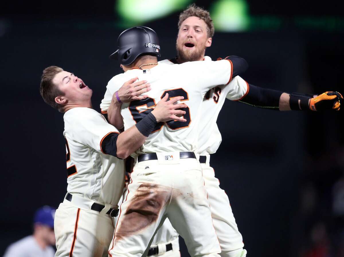 San Francisco Giants' Hunter Pence celebrates his 10th inning game-winning sacrifice fly with Christian Arroyo and Gorkys Hernandez after 4-3 win over Los Angeles Dodgers during MLB game at AT&T Park in San Francisco, Calif., on Wednesday, April 26, 2017.