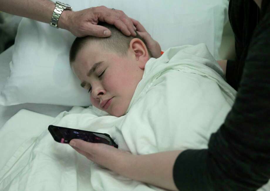 Brayden Large listens to his pastor, Justin Long, pray for him over the phone before his operation. Photo: Elizabeth Conley, Houston Chronicle / © 2017 Houston Chronicle