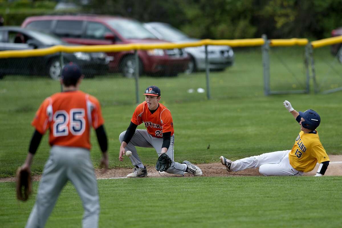 Midland High's Sam Vokal slides into third base before Flint Powers' Cam Conover can tag him out in the fifth inning of the Thursday afternoon game.