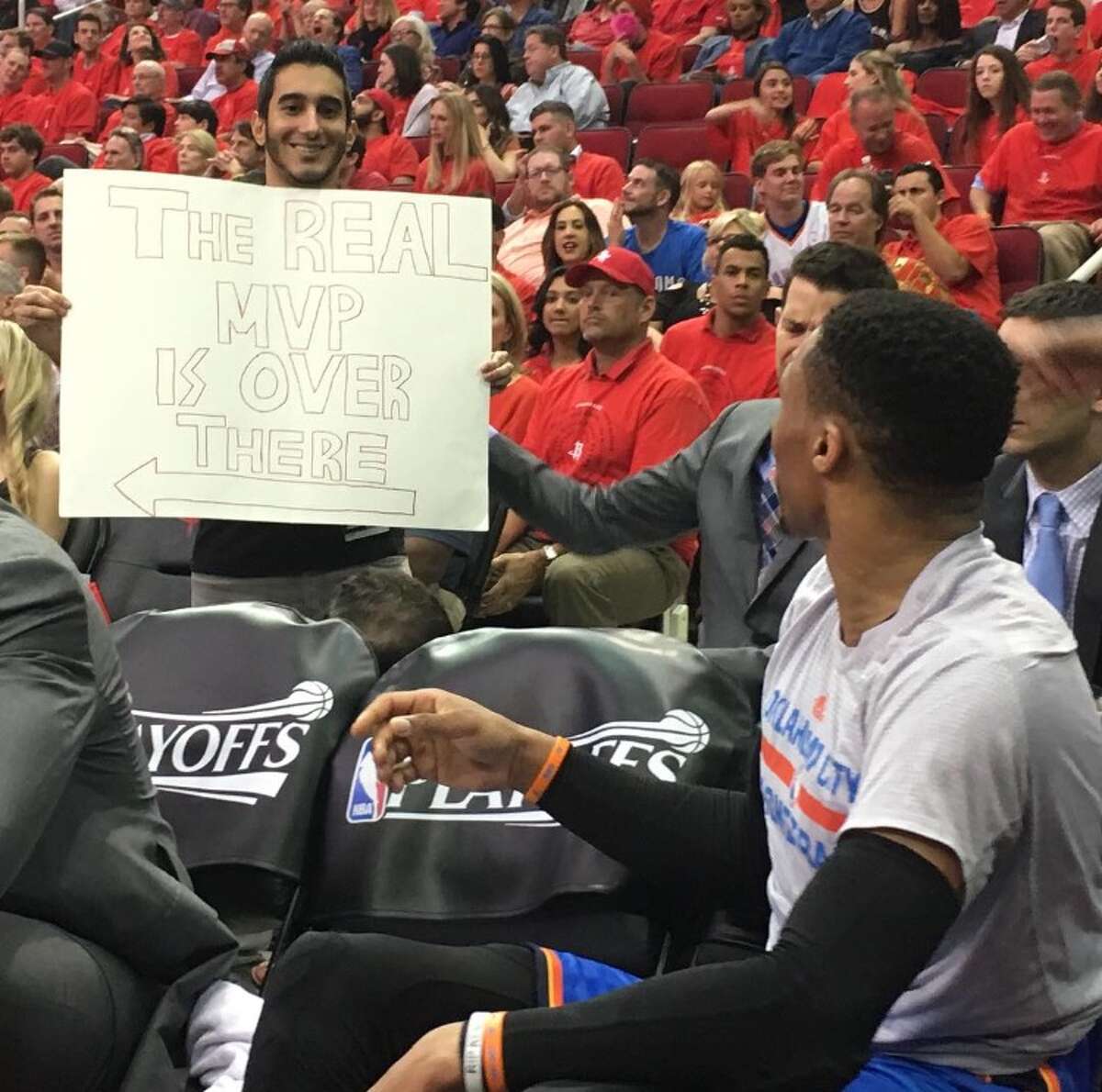 Houston Rockets fan Keeyan Sabz holds up a sign behind the NBA's 2016-17 likely Most Valuable Player, Russell Westbrook of the Oklahoma City Thunder, Tuesday April 24, 2017, during the Rockets playoff victory over the Thunder at Toyota Center. The sign, which says "The real MVP is over there," points toward Rockets guard James Harden. (Photo: Keeyan Sabz)
