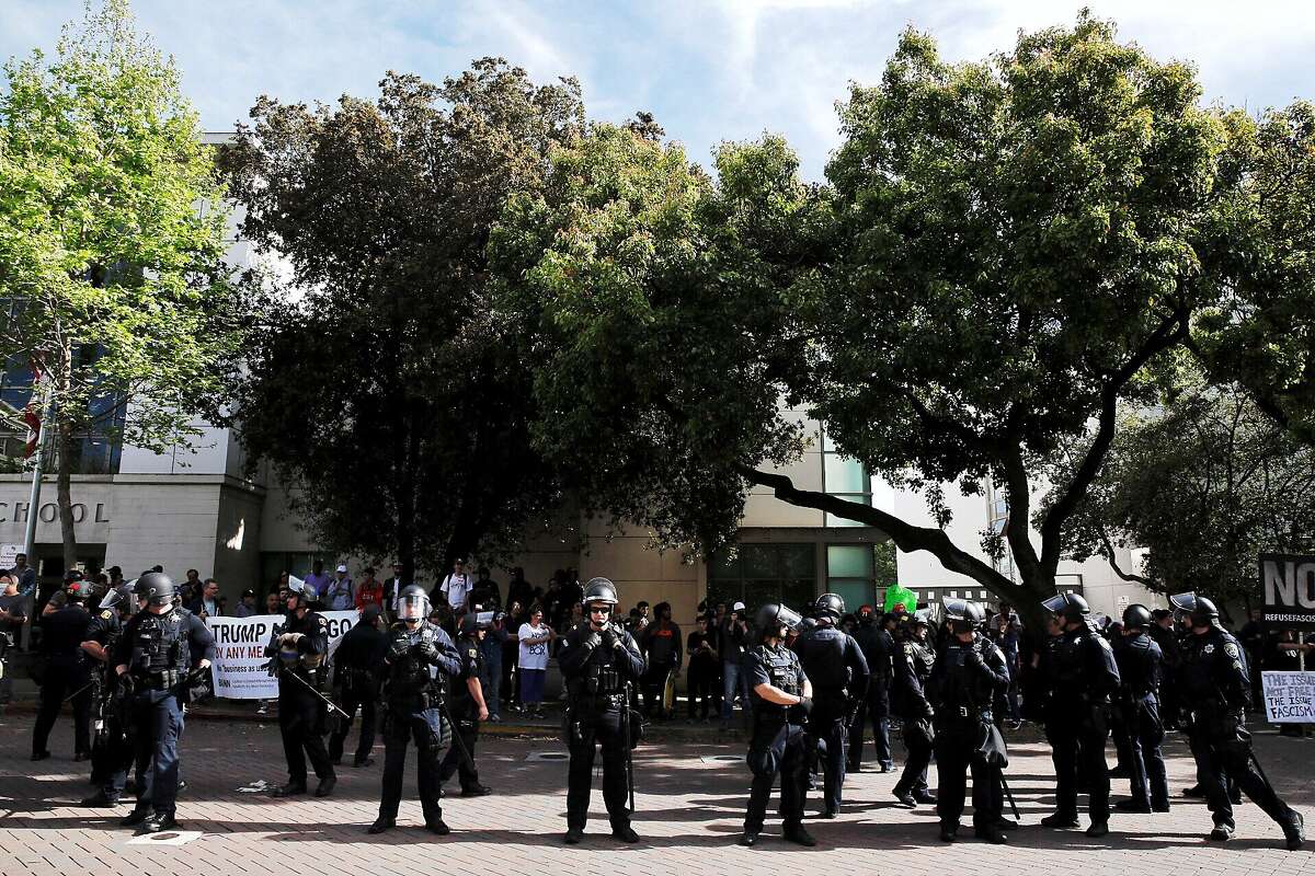 Dozens of police officers divide right wing and left wing demonstrators at MLK Park on Thursday, April 27, 2017, in Berkeley, Calif. Conservative commentator Ann Coulter was to speak at UC Berkeley, but cancelled after groups sponsoring her event no longer supported her appearance.