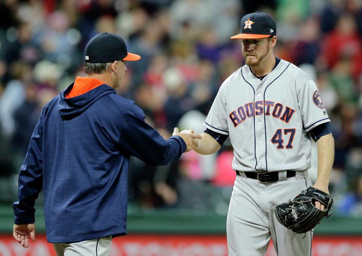 Houston Astros relief pitcher Chris Devenski, right, hands the ball off to manager A.J. Hinch during the seventh inning of the team's baseball game against the Cleveland Indians, Thursday, April 27, 2017, in Cleveland. (AP Photo/Tony Dejak)