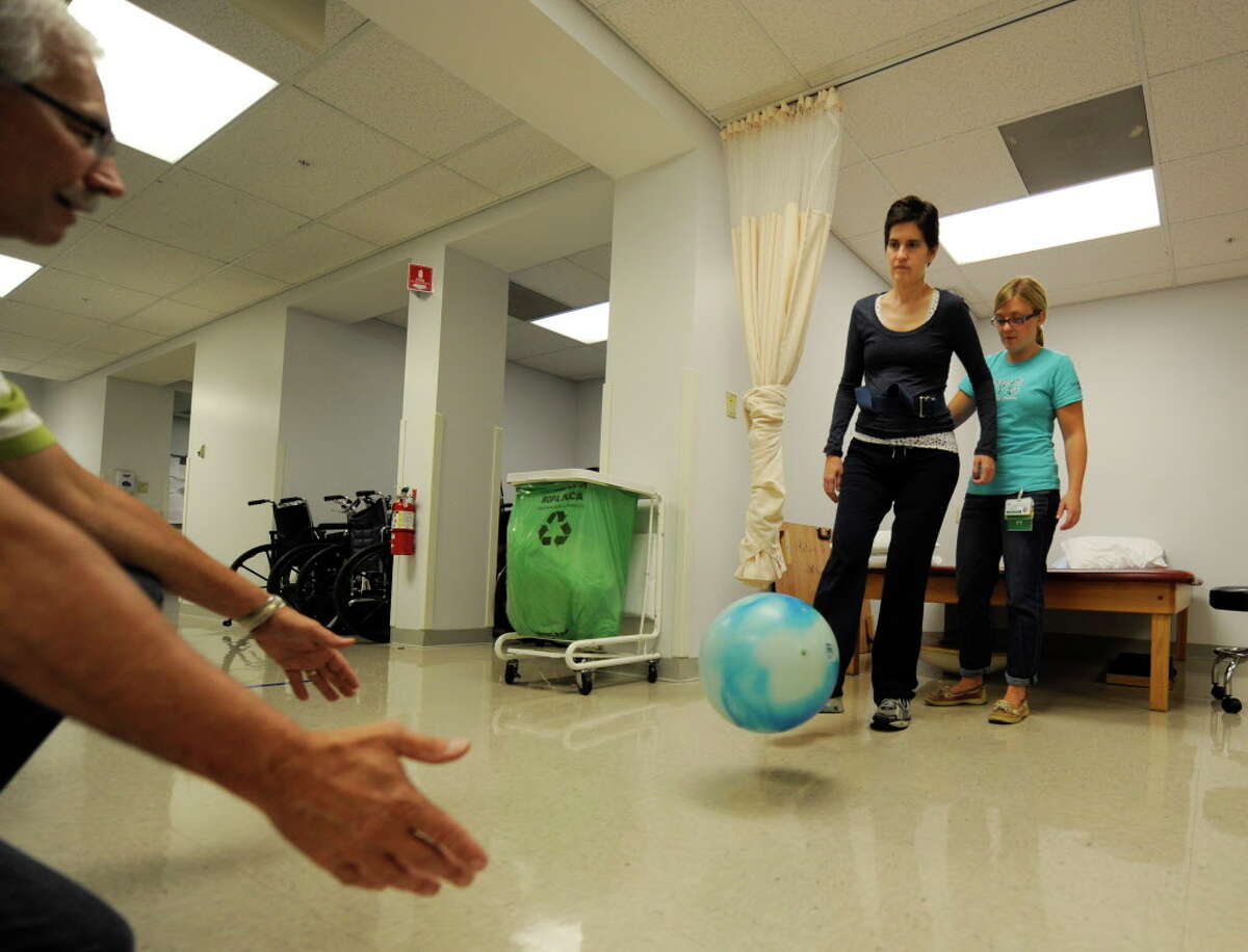 Jennifer Lasher Tinsmon, center is assisted with her physical therapy by Physical Therapist Brigid Kilroy, right and Gary Smith, right at the Sunnyview Rehabilitation Center in Schenectady, N.Y. September 23, 2011. (Skip Dickstein/Times Union)