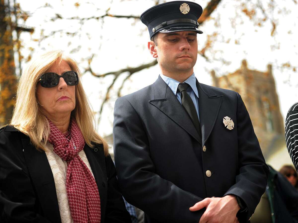 Karen Dumas Ackley, of Fairfield, and her nephew Kevin Dumas, Jr., of Milford, observe a moment of silence during the 30th anniversary ceremony of the L'Ambiance Plaza building collapse in Bridgeport on April 24.