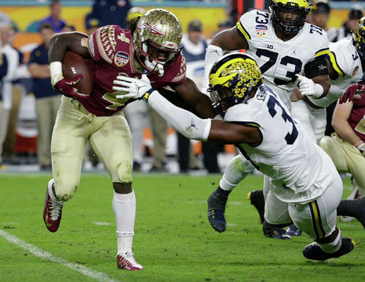 FILE - In this Dec. 30, 2016, file photo, Florida State running back Dalvin Cook (4) runs the ball as Michigan defensive end Taco Charlton (33) attempts to defend during the first half of the Orange Bowl NCAA college football game in Miami Gardens, Fla. After running backs failed to go in the first round of the NFL draft in 2013 and ’14, LSU’s Leonard Fournette, Stanford’s Christian McCaffrey and Cook could be selected on Thursday, April 27, 2017. (AP Photo/Lynne Sladky, File)