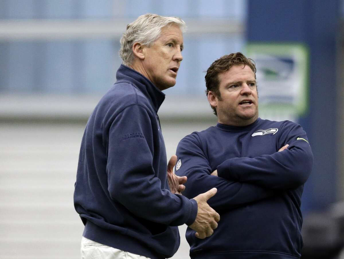 Seattle Seahawks head coach Pete Carroll, left, and general manager John Schneider talk during an NFL football rookie minicamp workout Sunday, May 8, 2016, in Renton, Wash. (AP Photo/Elaine Thompson)