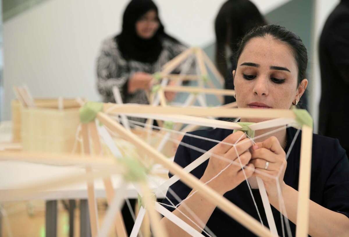 Samira Houshmand ties string while building lamps for an art installation, "Green Light," by Danish artist Olafur Eliasson at Rice University's Moody Center.