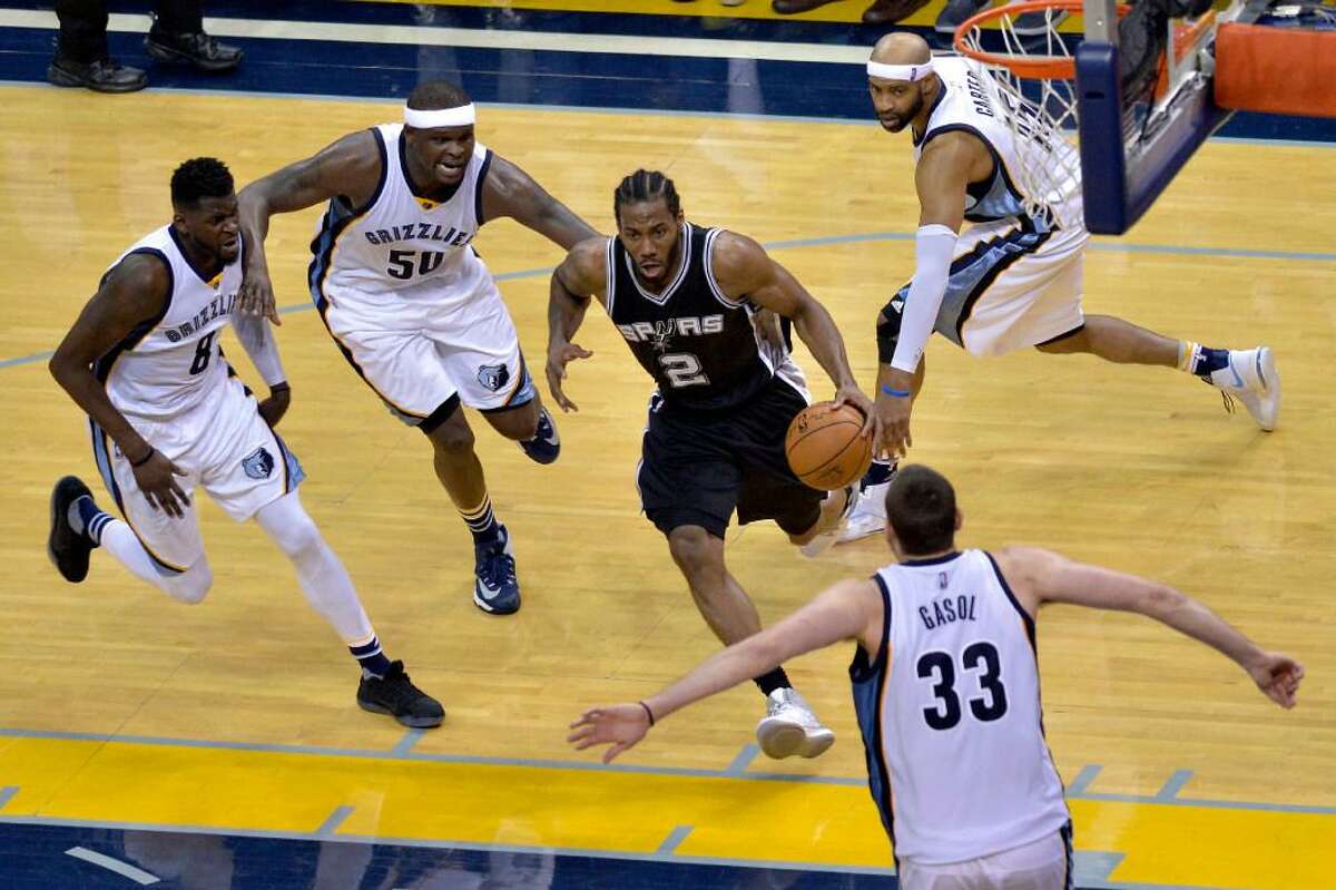 San Antonio Spurs forward Kawhi Leonard (2) drives to the basket between Memphis Grizzlies forward James Ennis (8), forward Zach Randolph (50), guard Vince Carter (15), and center Marc Gasol (33) during the second half of Game 6 in an NBA basketball first-round playoff series Thursday, April 27, 2017, in Memphis, Tenn. The Spurs won 103-96 and advanced to the second round.
