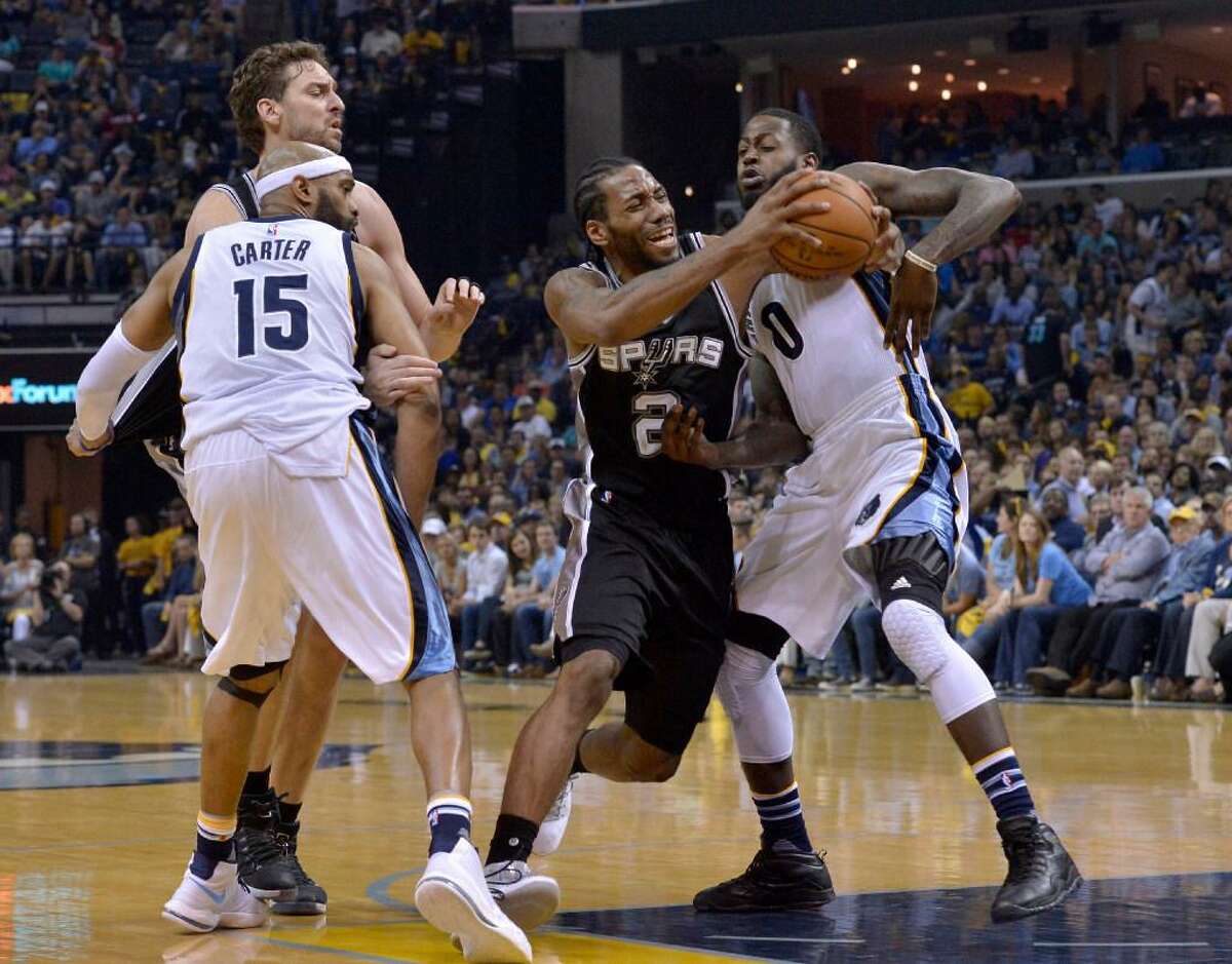 Kawhi Leonard drives against Memphis forward JaMychal Green (0) as Grizzlies guard Vince Carter (15) and Spurs center Pau Gasol, back left, move for position during the second half of Game 6 in an NBA basketball first-round playoff series Thursday, April 27, 2017, in Memphis, Tenn.