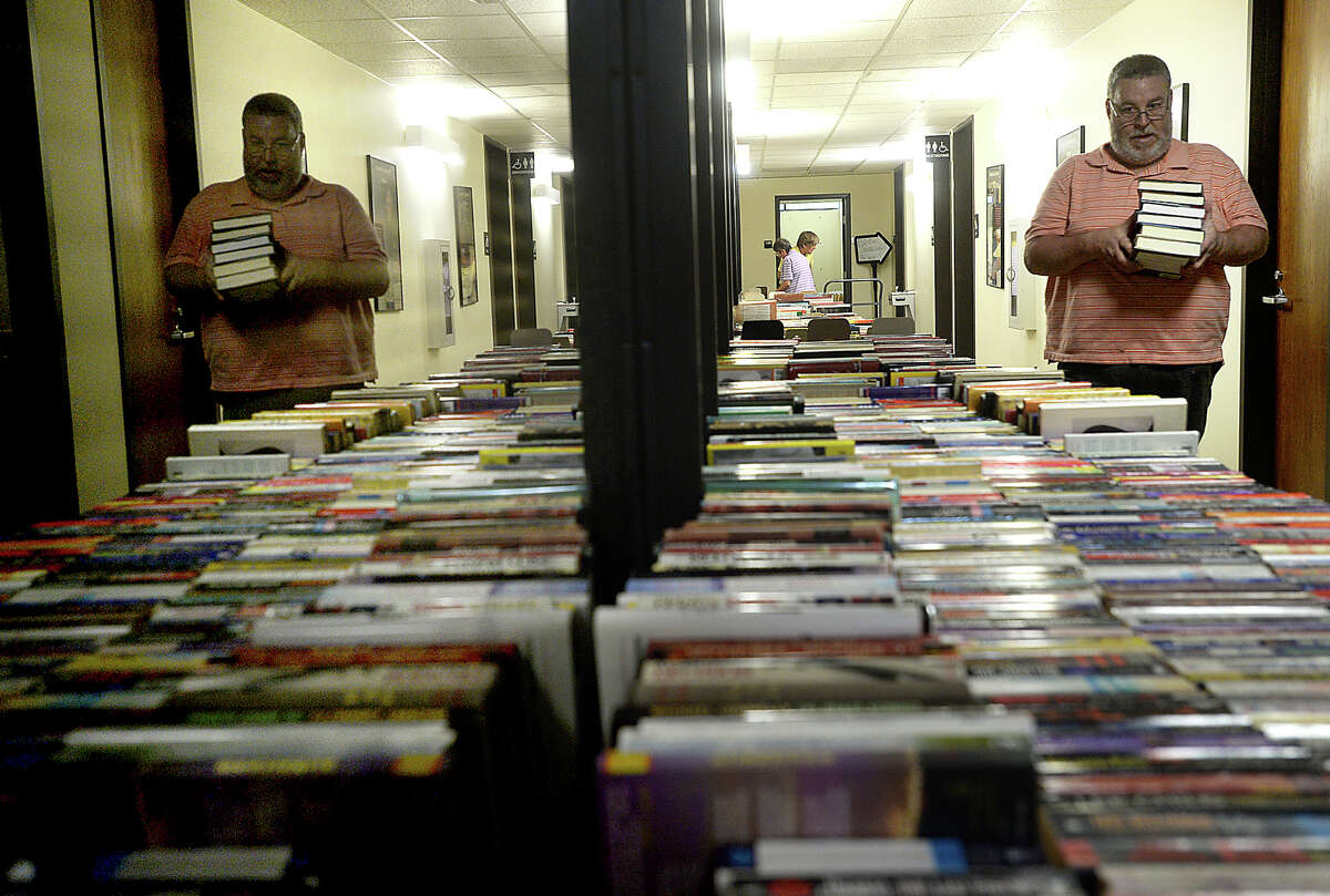 Members of Friends of the Beaumont Library and volunteers, including Rick Beaulieu, continue to sort and stack tables filled with books, videos, and books on tape as they prepare for the start of the Friends annual library book sale at the Main Branch in downtown Beaumont Friday. The event opens Friday to members of the group from 5 - 9 p.m. A $10 membership fee can be paid at the door for those wishing to join in the opening night of the sale. The sale continues free to the public Saturday from 9 a.m. - 4 p.m. All items are 10 cents, and there are thousands of titles from all genres of reading materials available, as well as a children's section. Photo taken Friday, April 28, 2017 Kim Brent/The Enterprise