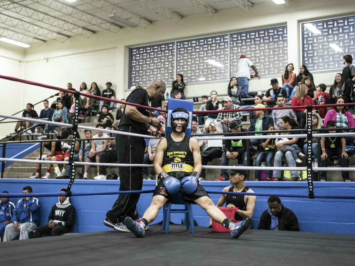 San Fernando Boxing Club coach Willie Hall, left, talks to his fighter Gerron Mena, in the corner during a boxing event at the Lincoln Community Center in San Antonio, Texas on Saturday, March 4, 2017.