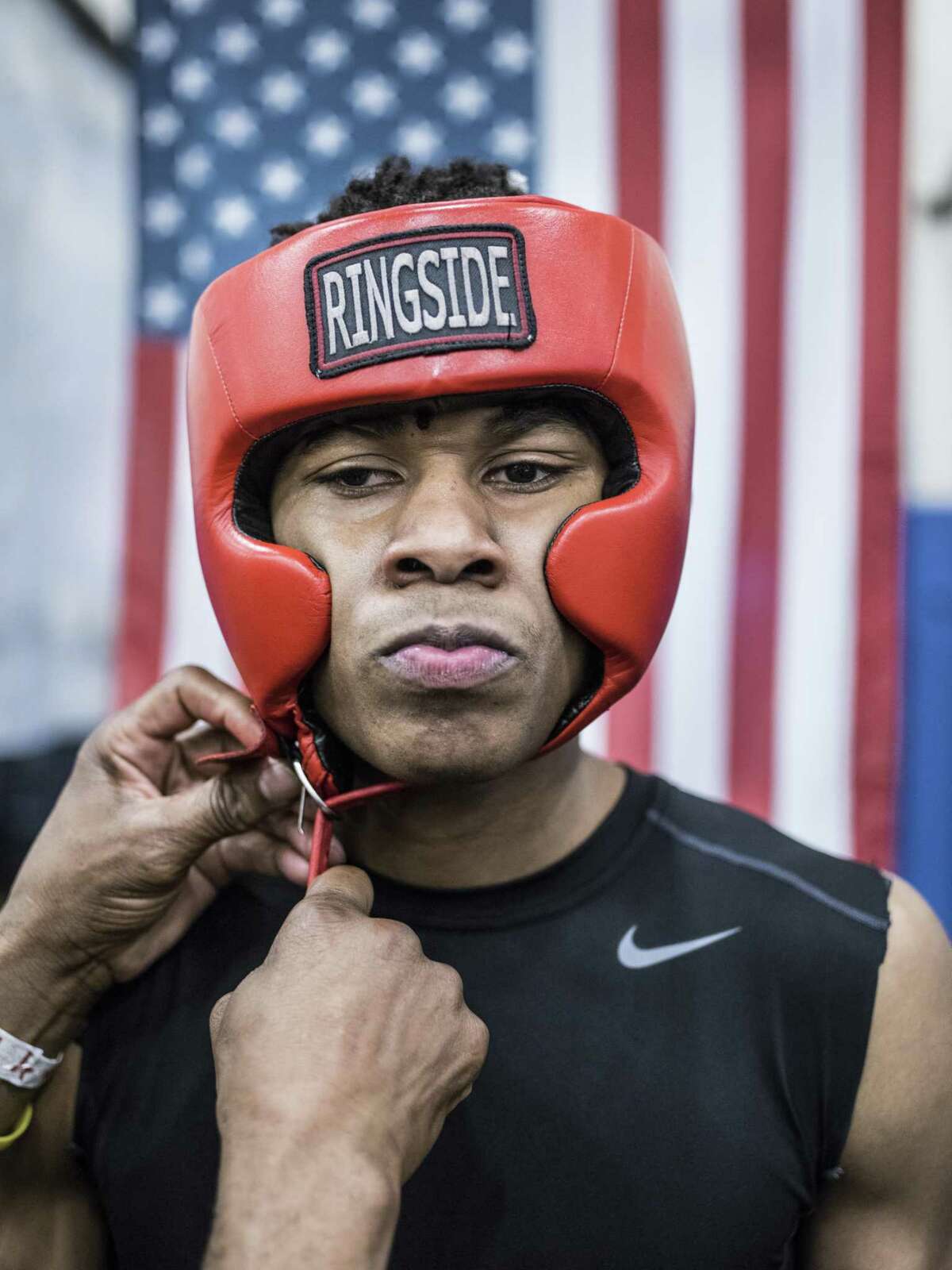 Joseph Barrow Jr., 20, from San Fernando Boxing Club, has his headgear put on before his first fight ever by longtime coach at San Fernando, Willie Hall, during a boxing event at the Lincoln Community Center in San Antonio, Texas on Saturday, March 4, 2017.
