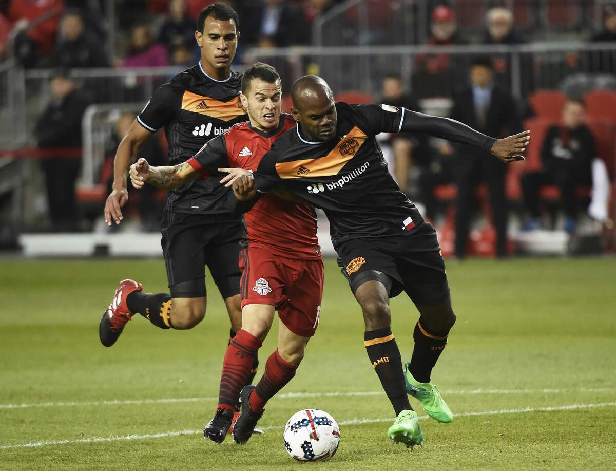 Toronto FC forward Sebastian Giovinco, middle, battles for the ball with Houston Dynamo defender Adolfo Machado, right, and midfielder Juan Cabezas during the first half of an MLS soccer match in Toronto on Friday, April 28, 2017. (Nathan Denette/The Canadian Press via AP)/The Canadian Press via AP)