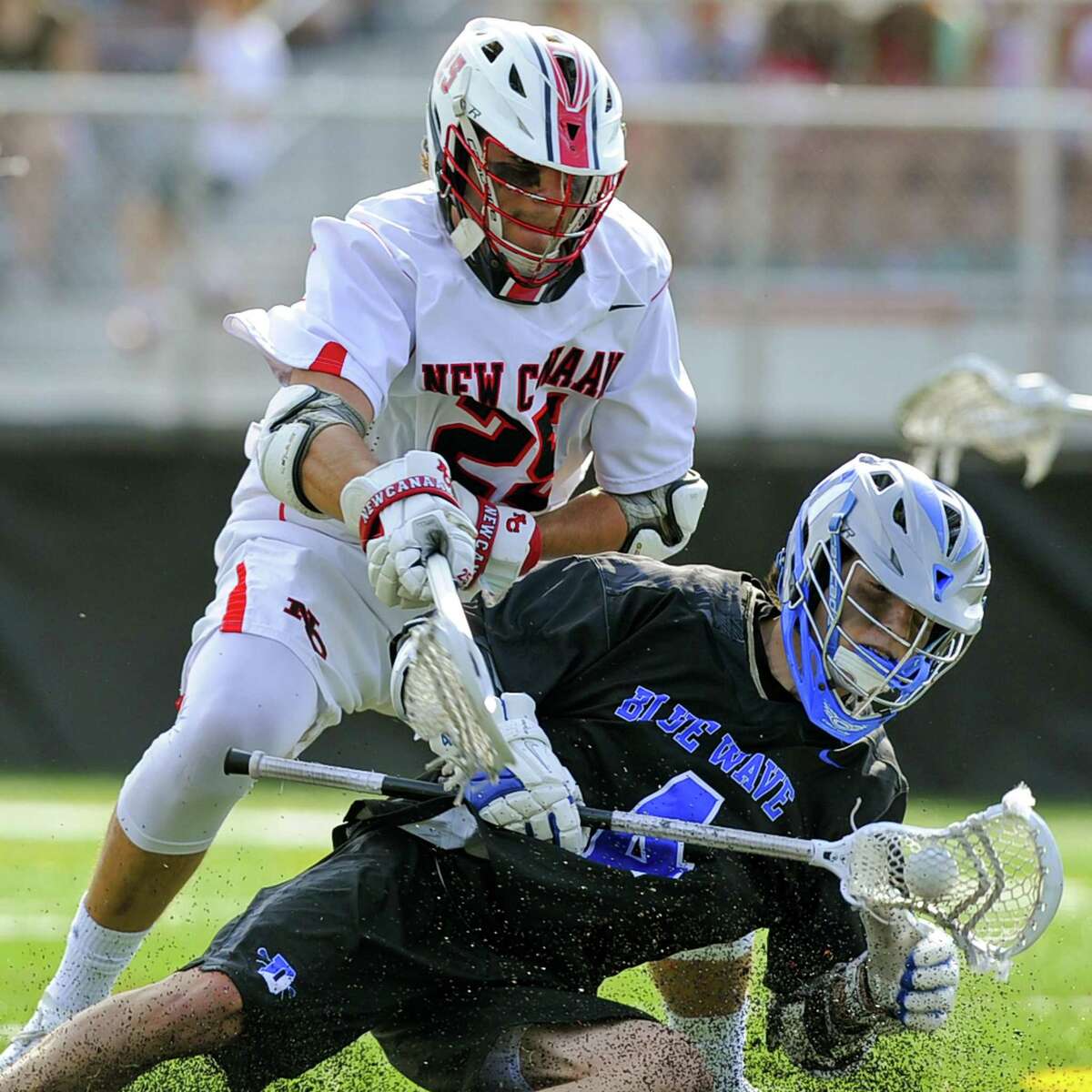 Darien Logan McGovern maintains control of the ball under pressure from New Canaan Andrew Bauersfeld in a FCIAC boys lacrosse game at New Canaan High School Dunning Field in New Canaan, Conn. on April 29, 2017. Darien defeated New Canaan 11-8.
