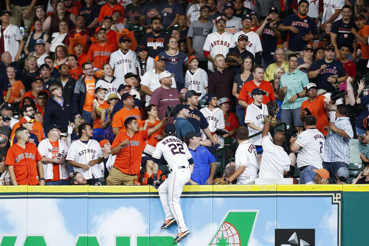 Houston Astros left fielder Josh Reddick (22) goes into the stands as he attempts to get an unreachable home run during the eighth inning as the Houston Astros take on the Oakland Athletics at Minute Maid Park Saturday, April 29, 2017 in Houston. ( Michael Ciaglo / Houston Chronicle)