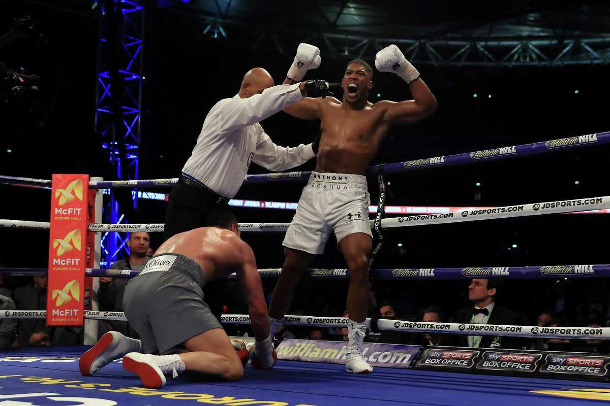 Anthony Joshua, right, celebrates after flooring Wladimir Klitschko in the fifth round of their heavyweight title fight at London. Joshua retained his three crowns.