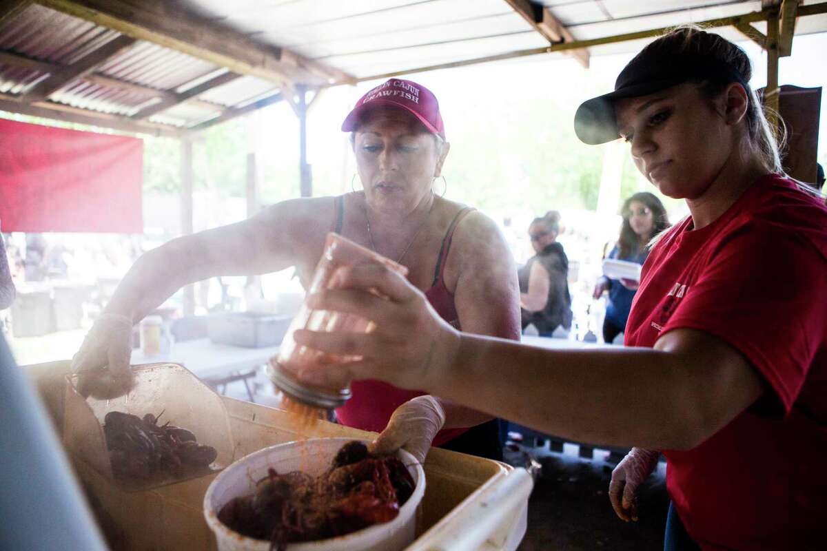 Sherry Whitfield, left, co-owner of Rollin Cajun Crawfish and Cheyenne Haynes, right, serve boiled crawfish at the Texas Crawfish and Music Festival, Sunday, April 30, 2017, in Spring.