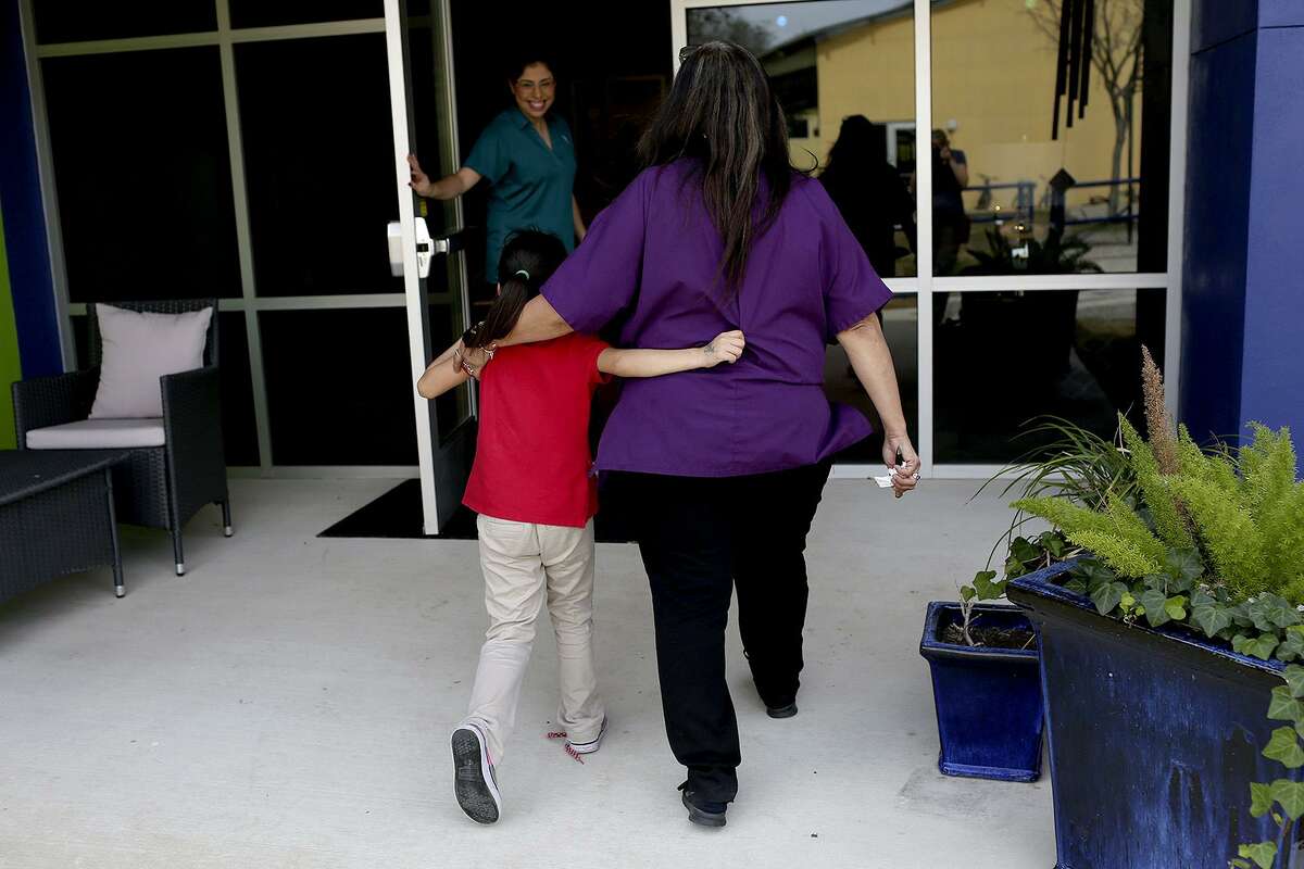 Youth care specialist Elizabeth Raya walks with a girl to a counseling session at The Children's Shelter in San Antonio on Feb. 7, 2017.