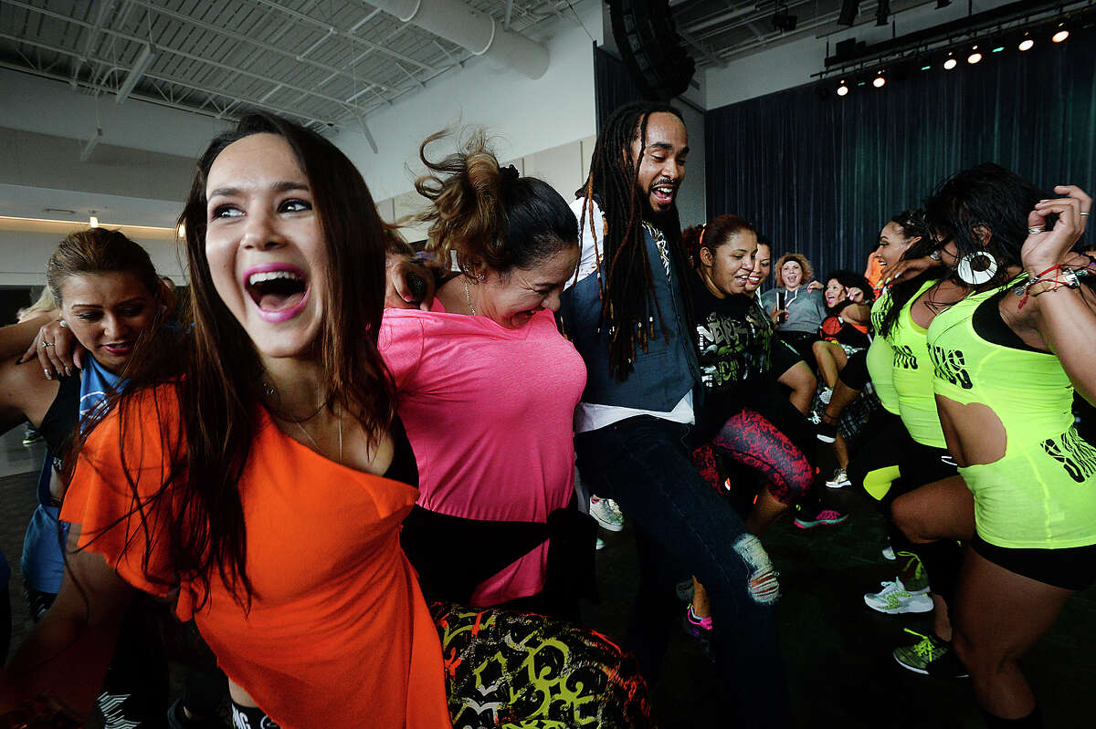Raquel Ellie Ibarra (left) and others join in a spirited group dance during the "Set the Floor on Fiah" Zumba fitness concert at the Event Centre in Beaumont Sunday. Famous performer Watatah Fiah (center) & DJ Mauricio kept the beats pounding as zumba enthusiasts danced their way to fitness. Proceeds from the event benefitted Child Abuse and Forensic Services, a non-profit organization that treats and offers legal services for abused children and victims of sexual assault. Photo taken Sunday, April 30, 2017 Kim Brent/The Enterprise