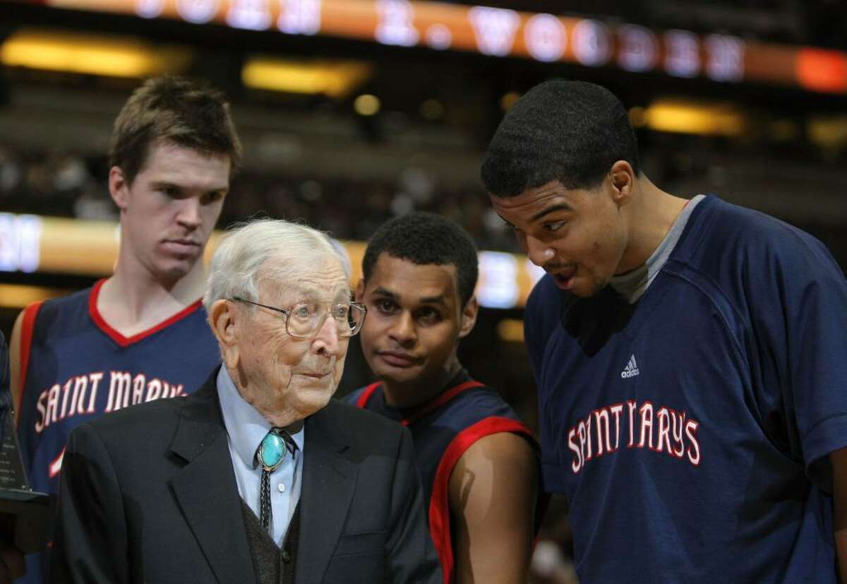 ANAHEIM, CA - DECEMBER 08: John Wooden chats with Yusef Smith #5, Patrick Mills #13 and Lucas Wlaker #12 of the St Mary's College Gaels after a 69-64 win over the San Diego State Aztecs during the John Wooden Classic at the Honda Center on December 8, 2007 in Anaheim, California. (Photo by Harry How/Getty Images)