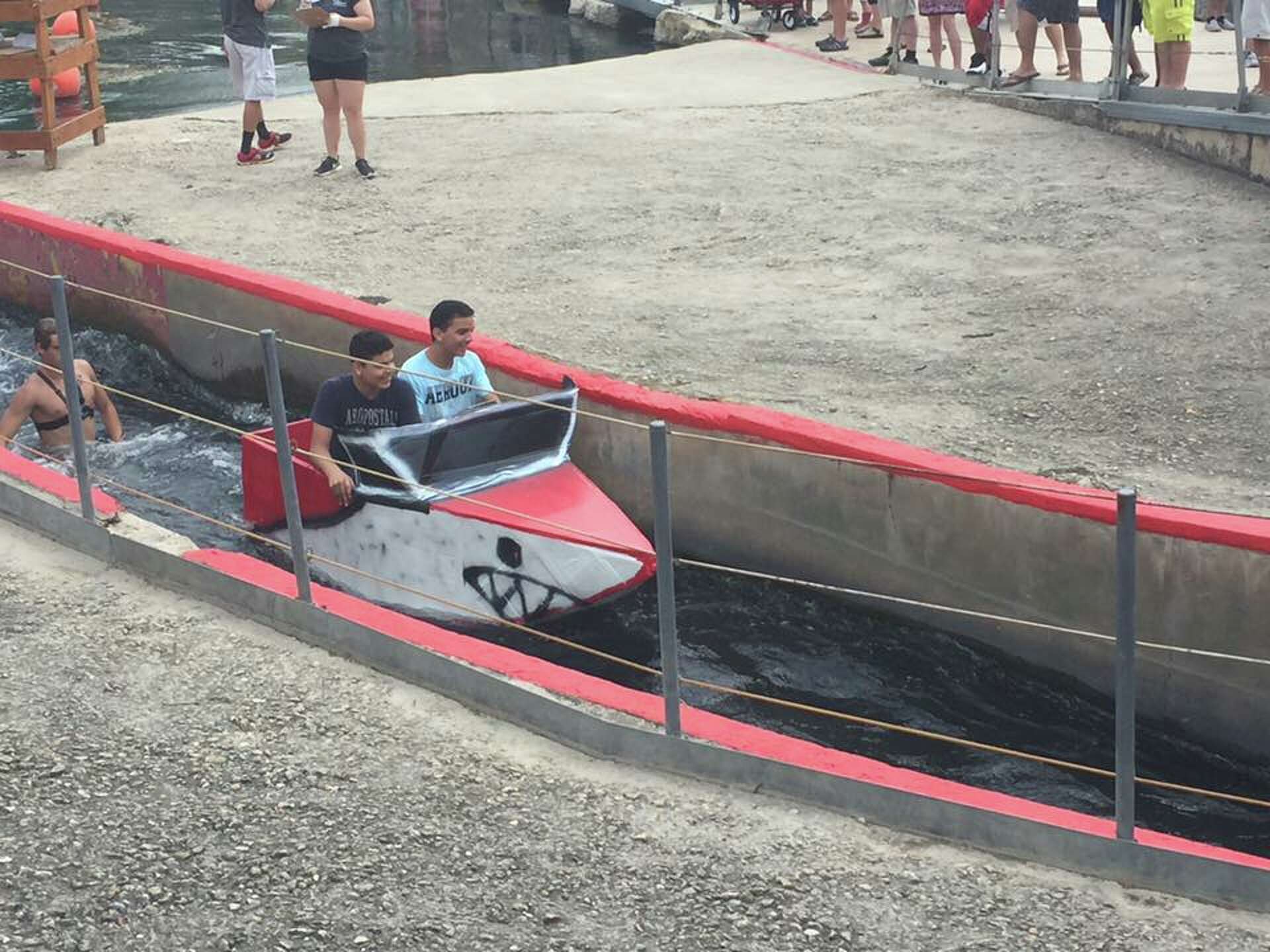 Competitors sail New Braunfels Thru the Chute Boat Race as icons